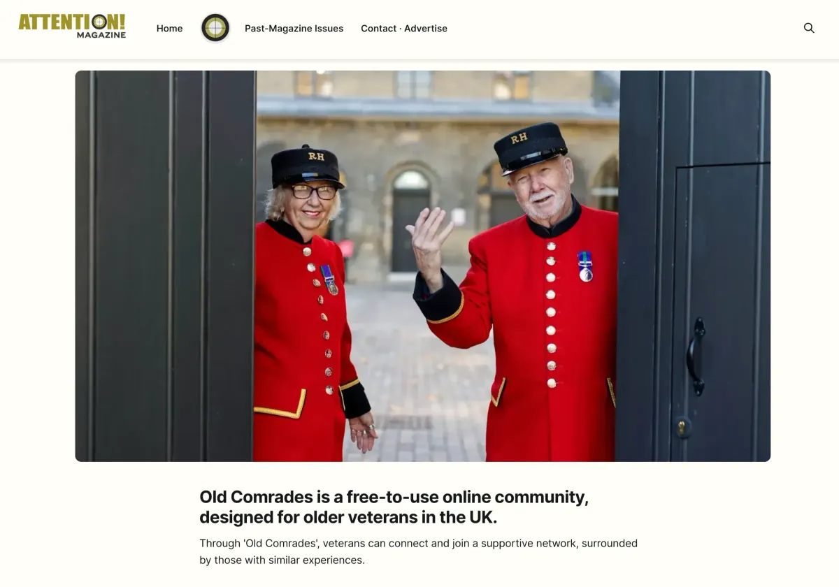 Two older veterans in red uniforms and hats with "RH" stand by a gate
