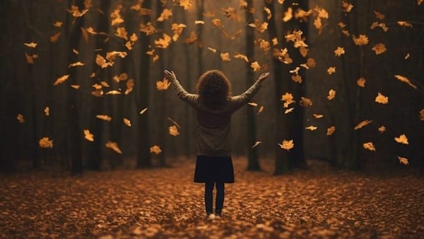 A woman standing in a wood during autumn surrounded by falling leaves.